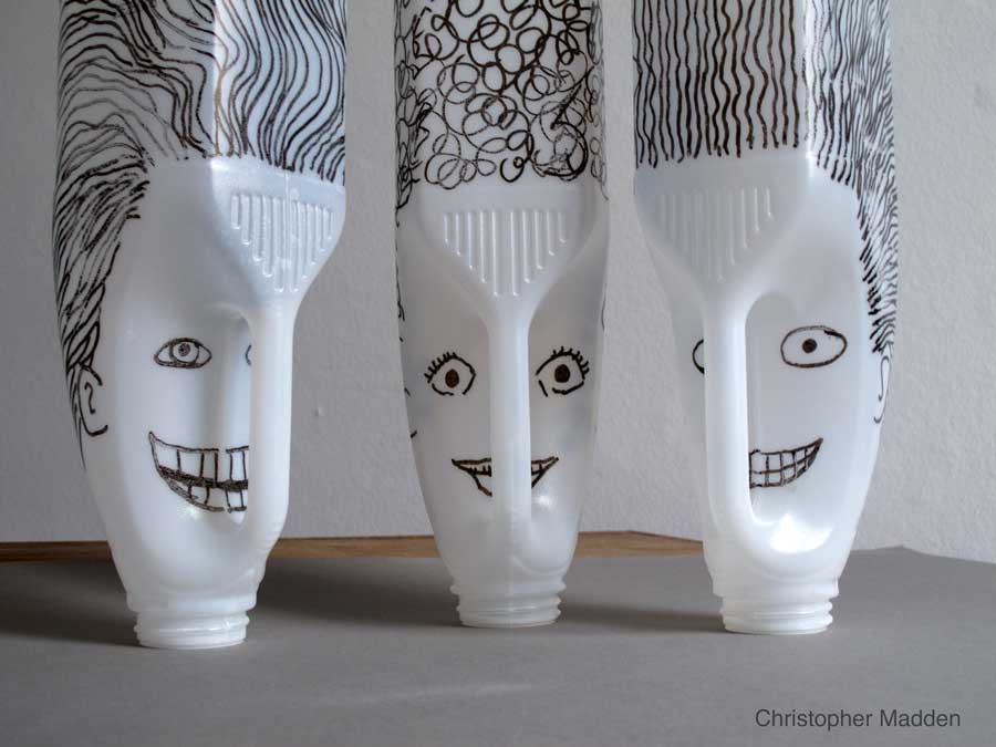 contemporary environmental art sculpture created from consumer waste - heads created from plastic milk bottles