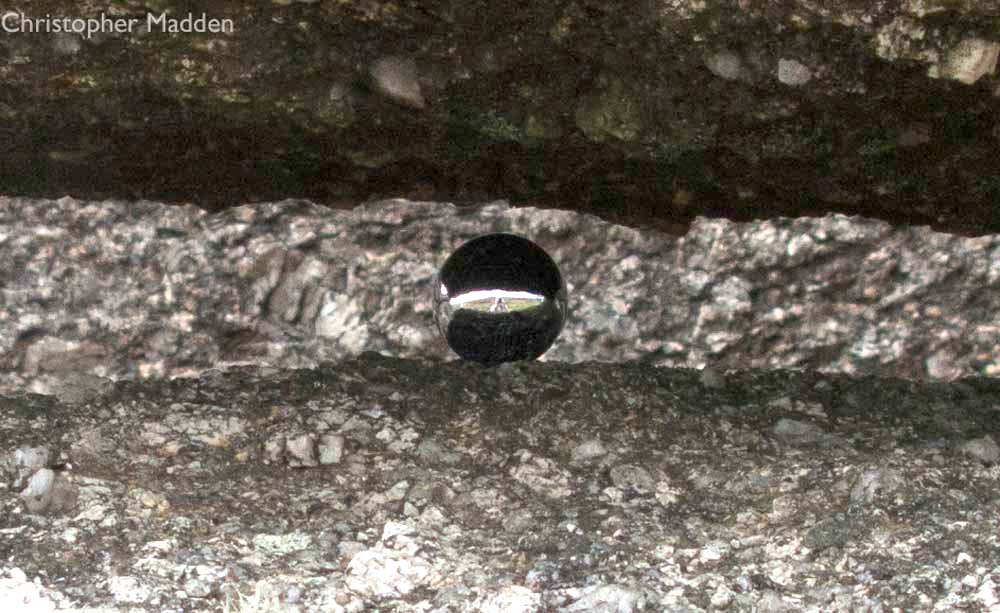 Steel ball on rock formation near St Ives Steel ball on rock formation near St Ives - art in the environment