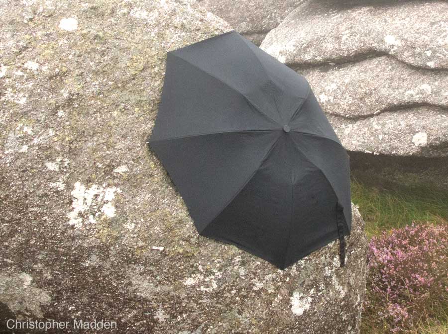 contemporary land art - umbrella clinging to a rock, Cornwall