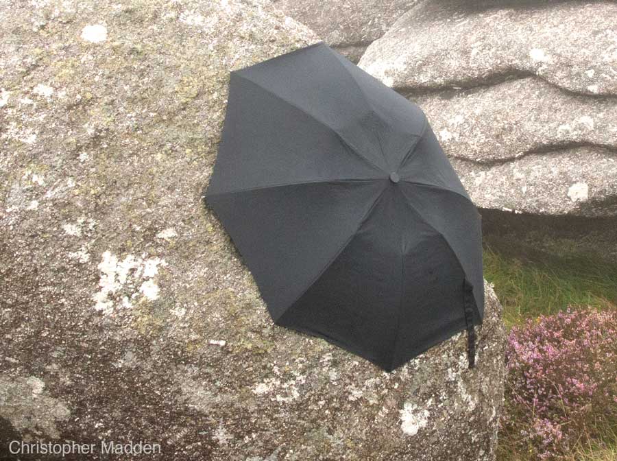 contemporary art in the environment - umbrella clinging to a rock, Cornwall